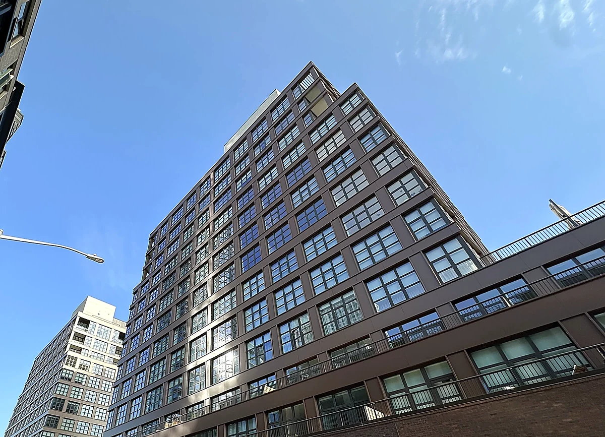 Upward view of Huron building facades and windows against blue sky